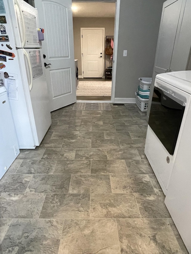 kitchen with white refrigerator and washer / dryer