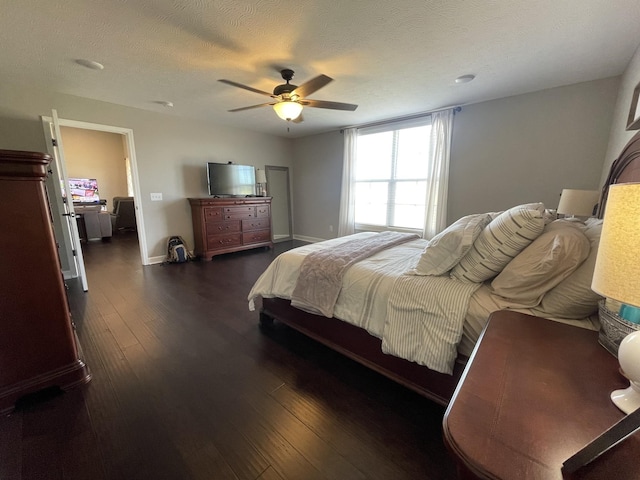 bedroom with ceiling fan, dark hardwood / wood-style flooring, and a textured ceiling