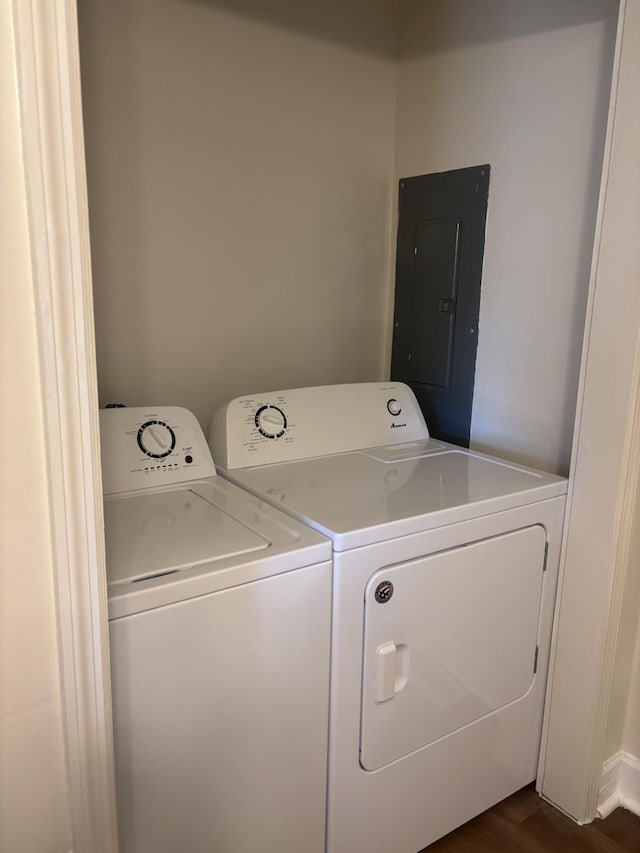 laundry room with dark wood-type flooring, electric panel, and washing machine and dryer