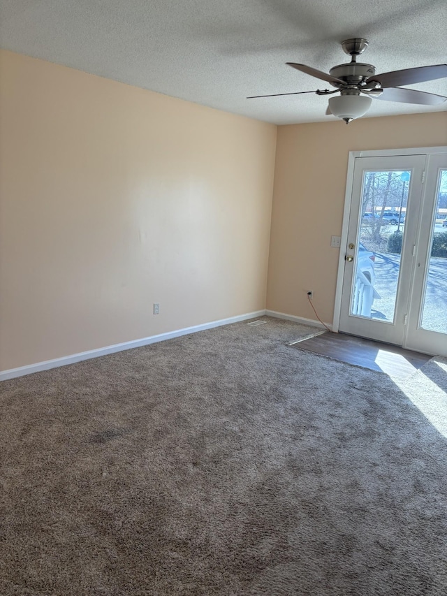 carpeted spare room with ceiling fan and a textured ceiling