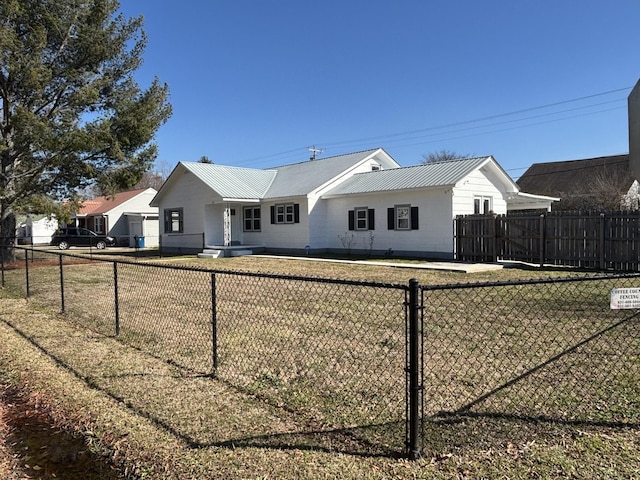 view of front of house with metal roof, a front yard, and fence private yard