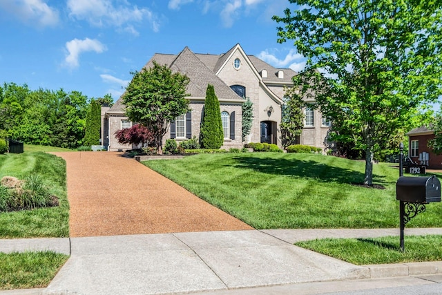 french provincial home with a front yard