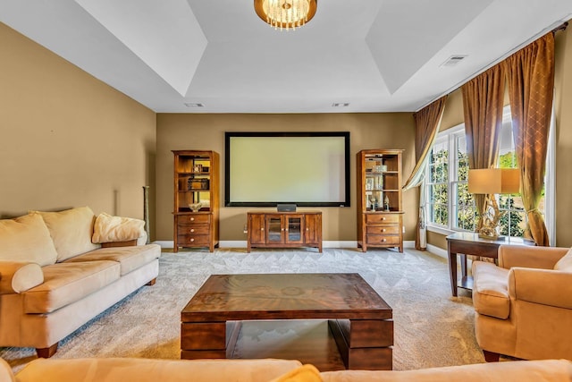 carpeted home theater featuring a raised ceiling