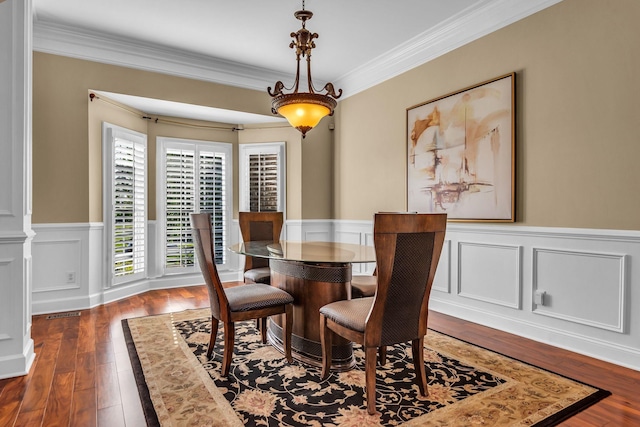 dining space featuring crown molding and dark wood-type flooring