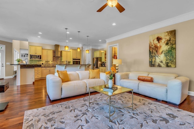 living room featuring wood-type flooring, ornamental molding, and ceiling fan