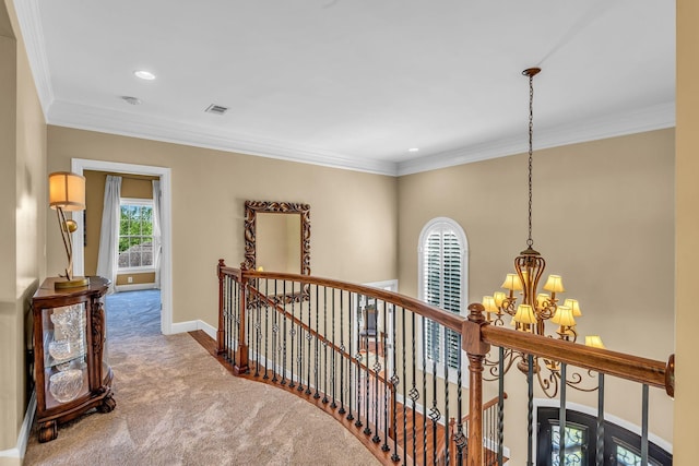 hall featuring an inviting chandelier, carpet floors, and ornamental molding