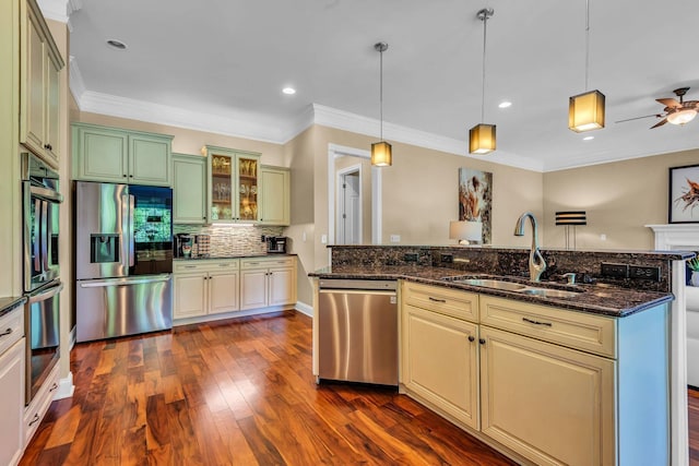 kitchen with sink, hanging light fixtures, stainless steel appliances, tasteful backsplash, and dark stone counters