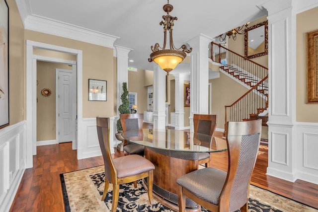 dining space featuring ornamental molding, dark hardwood / wood-style flooring, and ornate columns