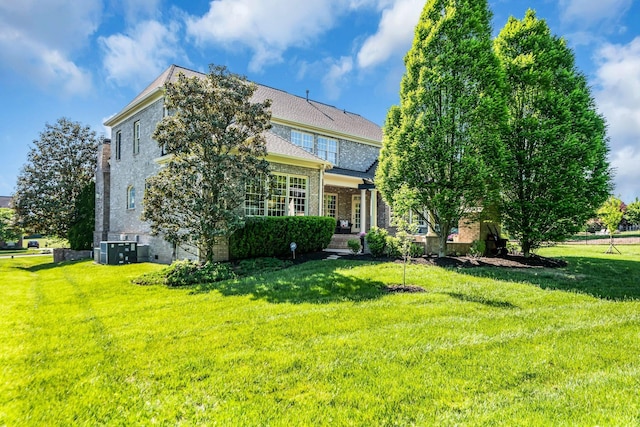 view of front of home featuring central AC and a front yard