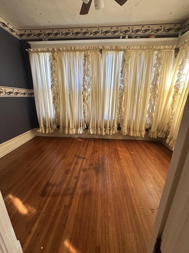 unfurnished room featuring a textured ceiling, wood-type flooring, and ceiling fan