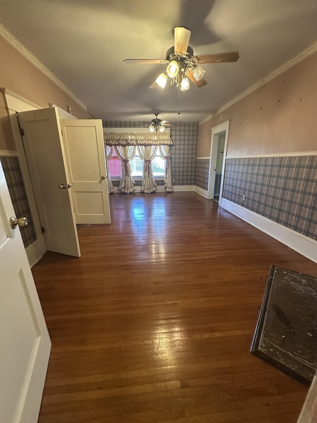 empty room with dark hardwood / wood-style flooring, crown molding, and ceiling fan