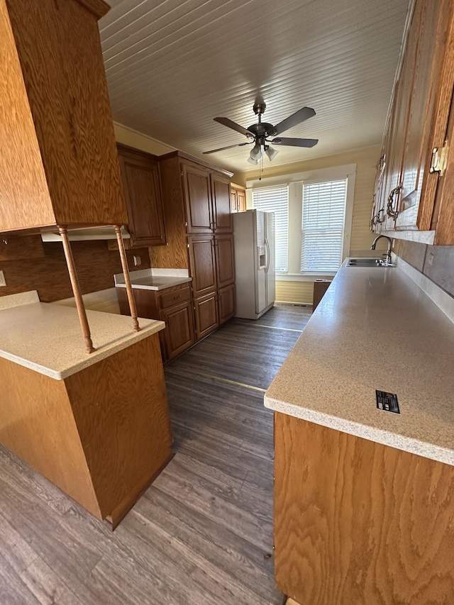 kitchen with sink, dark hardwood / wood-style floors, kitchen peninsula, ceiling fan, and white refrigerator with ice dispenser