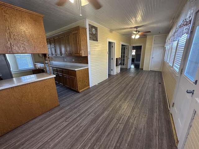 kitchen with dark hardwood / wood-style floors, black refrigerator, and ceiling fan