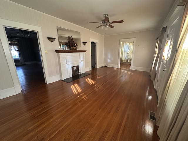 unfurnished living room with crown molding, ceiling fan, and dark hardwood / wood-style flooring