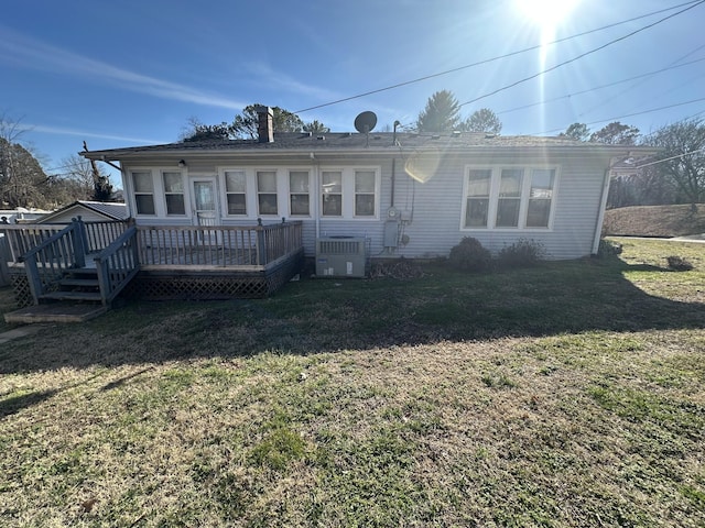 view of front of house with central AC, a deck, and a front yard