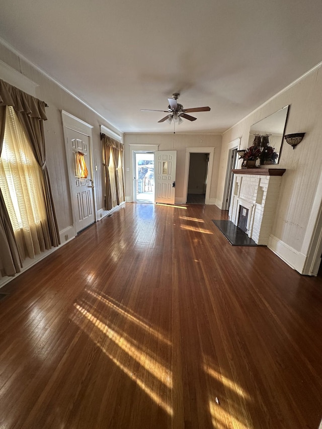 unfurnished living room featuring dark hardwood / wood-style flooring, ceiling fan, and a fireplace