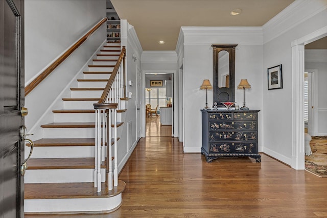 foyer entrance featuring crown molding and dark hardwood / wood-style flooring