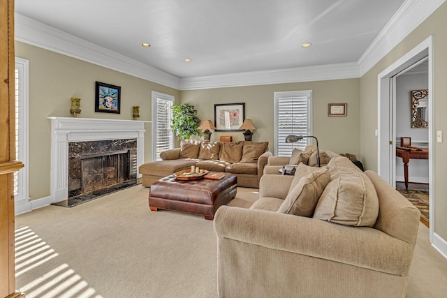 carpeted living room featuring a premium fireplace, ornamental molding, and a wealth of natural light