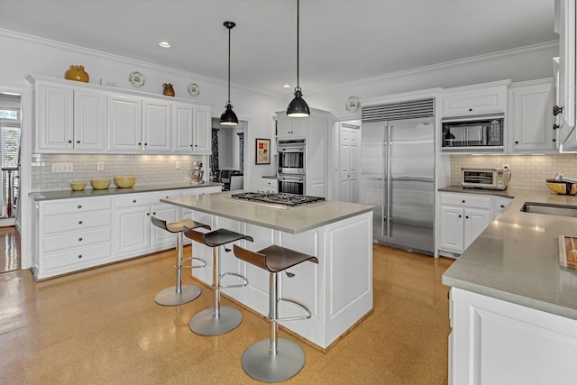 kitchen featuring built in appliances, hanging light fixtures, a center island, and white cabinets