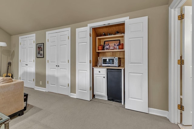 interior space featuring vaulted ceiling and light carpet