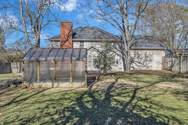 rear view of property with a yard and an outbuilding