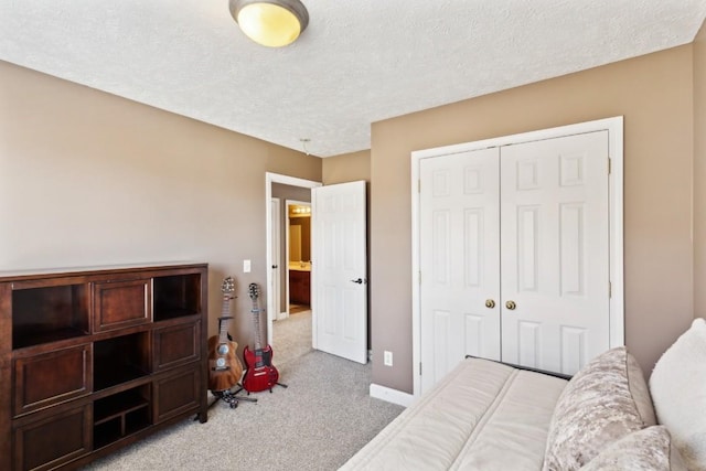 bedroom with light colored carpet, a textured ceiling, and a closet