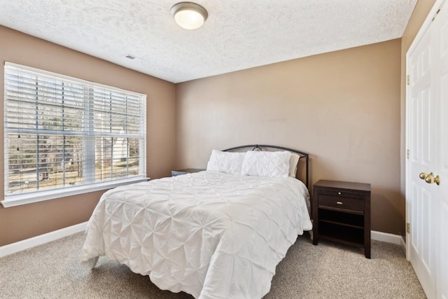 carpeted bedroom featuring a textured ceiling