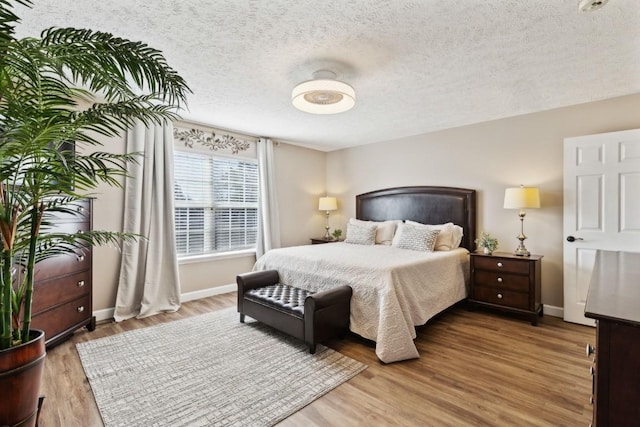 bedroom with hardwood / wood-style floors and a textured ceiling