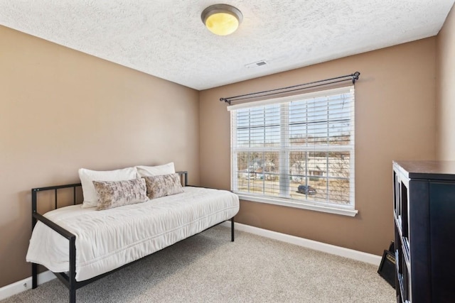 bedroom with light colored carpet and a textured ceiling