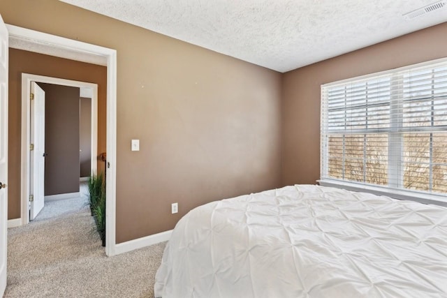 bedroom with light carpet and a textured ceiling