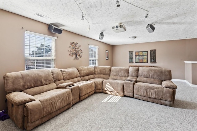 living room featuring light colored carpet, rail lighting, and a textured ceiling