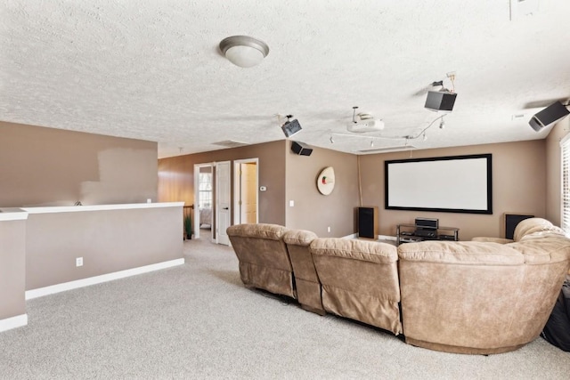 cinema room with light carpet and a textured ceiling