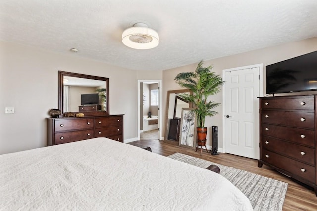 bedroom featuring a textured ceiling and light hardwood / wood-style flooring