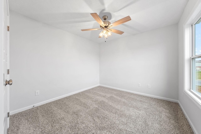 unfurnished room with ceiling fan and carpet