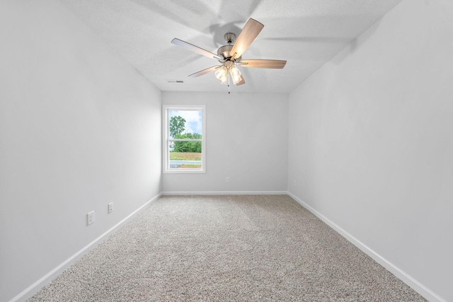 empty room featuring ceiling fan, carpet, and a textured ceiling