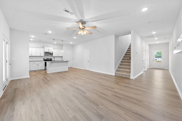 unfurnished living room with ceiling fan and light wood-type flooring