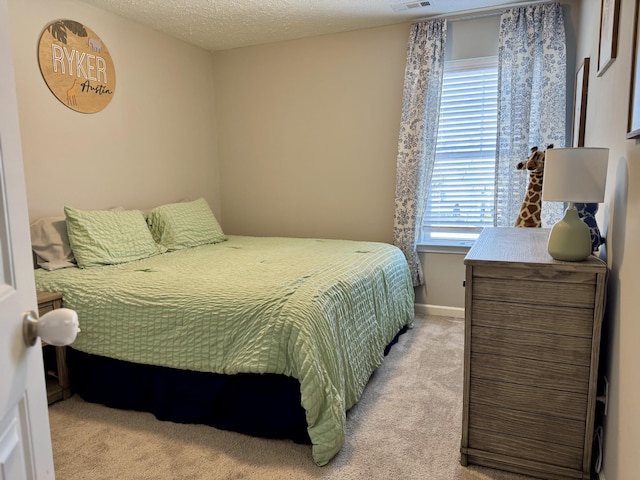 bedroom featuring light colored carpet and a textured ceiling