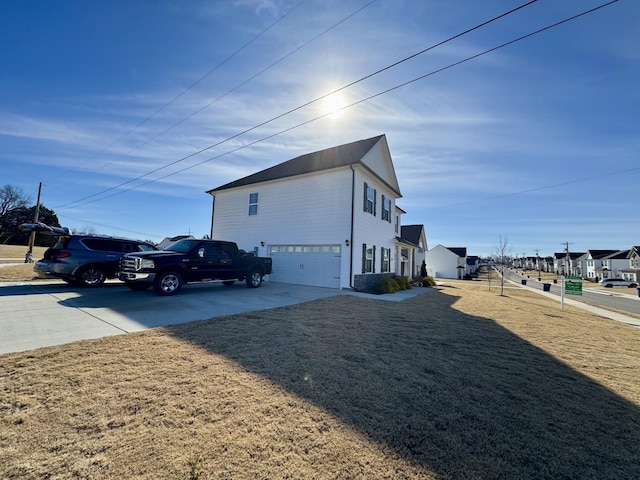 view of side of home featuring a garage and a yard