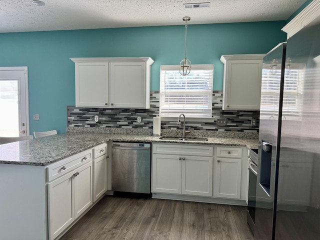 kitchen featuring appliances with stainless steel finishes, sink, white cabinets, and kitchen peninsula