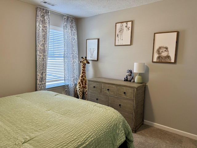 bedroom with multiple windows, light colored carpet, and a textured ceiling