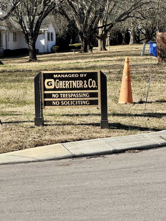 community / neighborhood sign with a yard