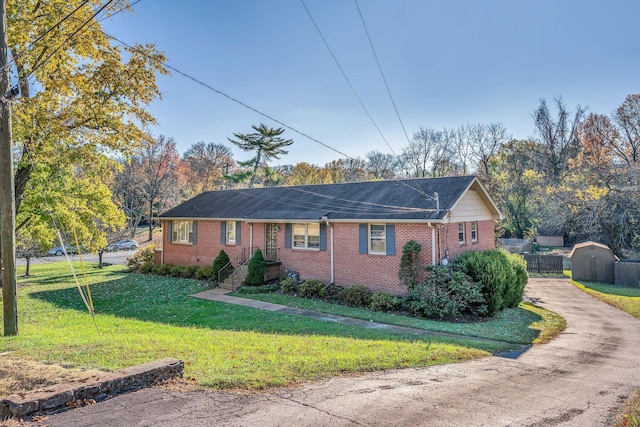 ranch-style house with a shed and a front lawn