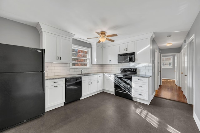 kitchen with tasteful backsplash, white cabinetry, sink, light stone counters, and black appliances