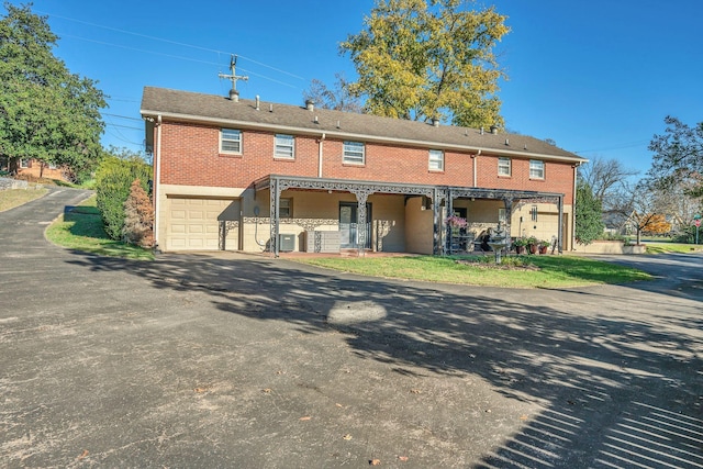 back of property with a garage and cooling unit