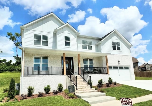 view of front of house with a garage, a front lawn, and covered porch