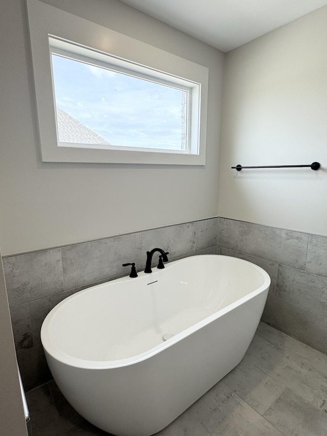 bathroom featuring tile walls and a tub