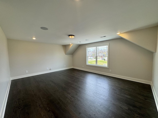 bonus room featuring vaulted ceiling and dark wood-type flooring