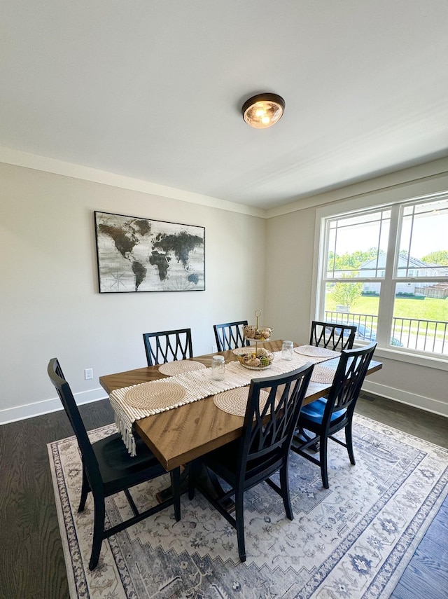 dining area with ornamental molding and dark hardwood / wood-style flooring