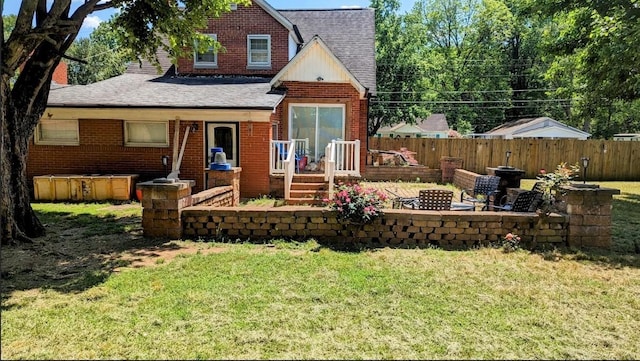 back of house featuring a fire pit and a lawn