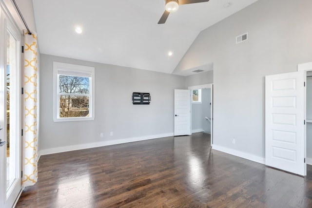 empty room with dark wood-type flooring, ceiling fan, and high vaulted ceiling